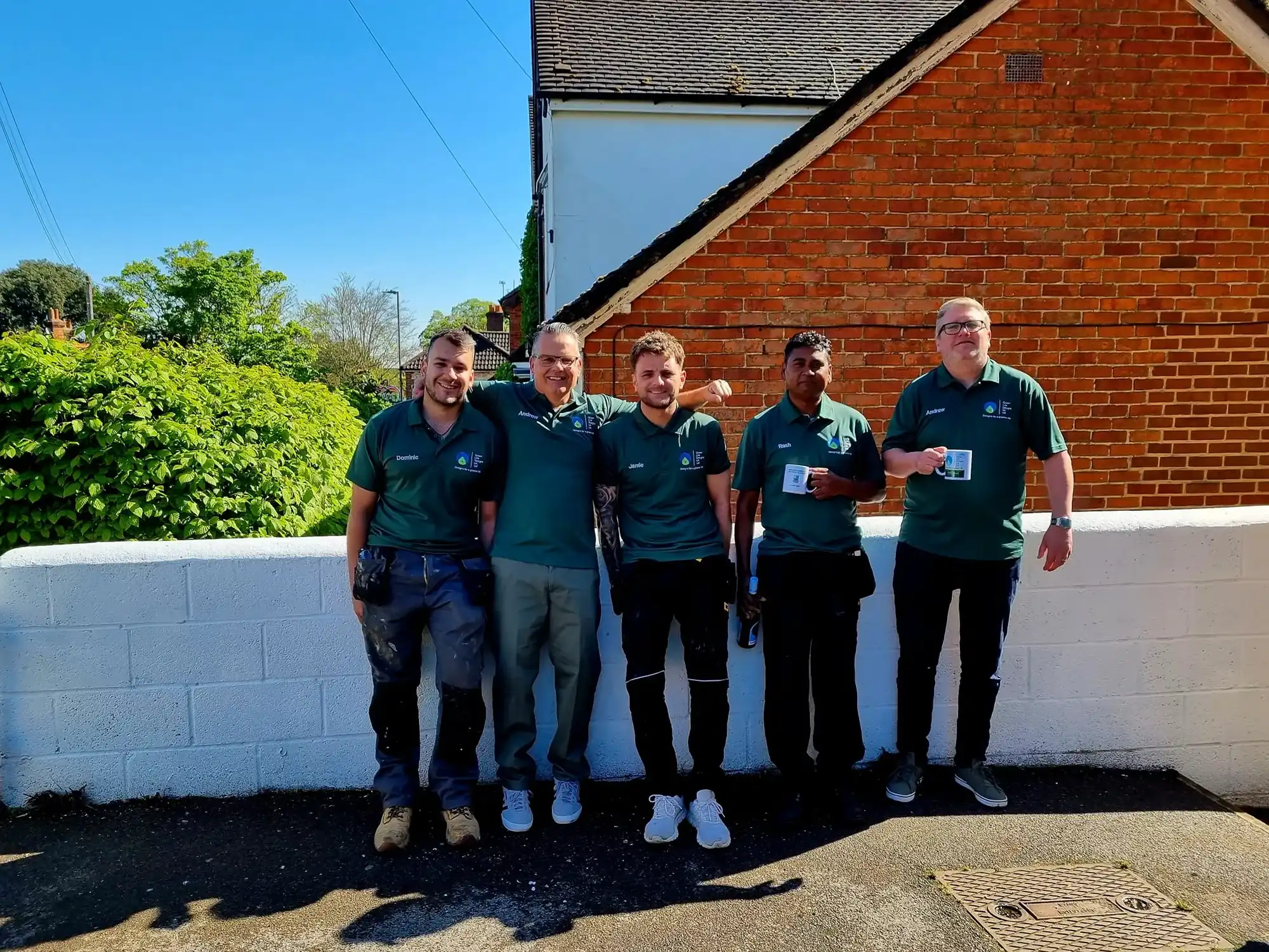 group of men standing next to a brick wall